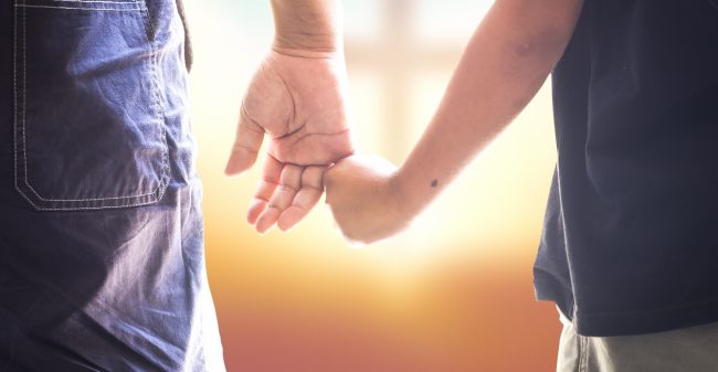 Kleine handjes op de kist van opa